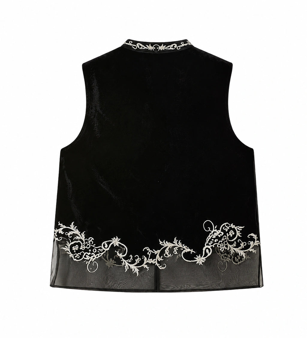 Back view of a jet-black mulberry silk velvet vest with ivory floral embroidery and a sheer paneled hem.