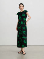 Side view of a slim-fitting black silk maxi dress with green floral print and cap sleeves.