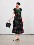 Woman wearing a black 100% mulberry silk midi dress with colorful hydrangea flowers.