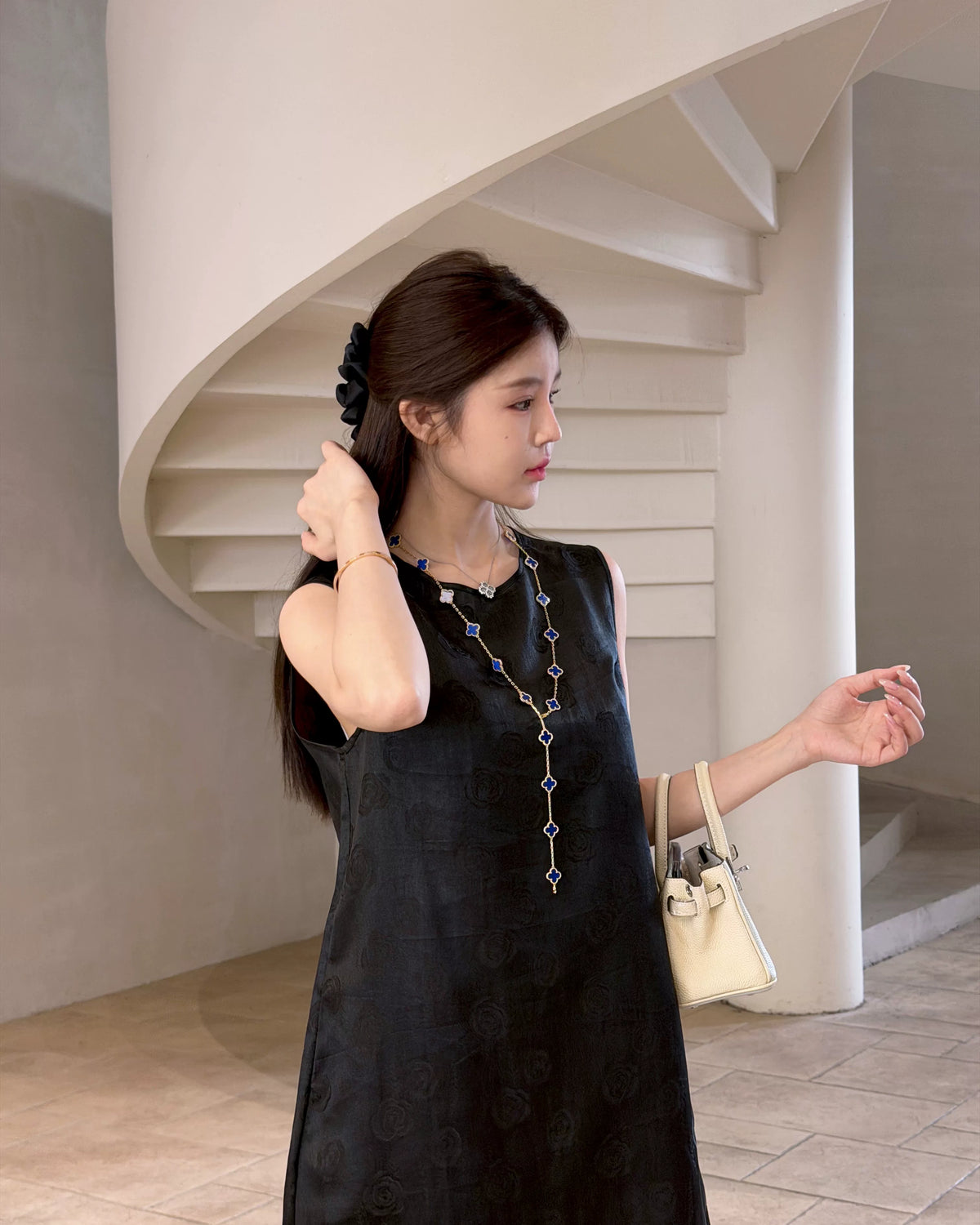 Side view of a model wearing a premium black sleeveless mulberry silk dress with a relaxed H-line silhouette.