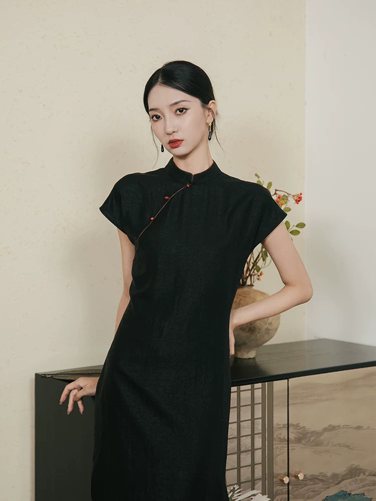 Close-up of black mulberry silk Mandarin collar dress with handmade frog-button detail