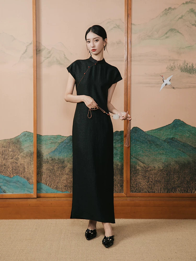 Woman wearing a black mulberry silk Mandarin collar maxi dress in an Oriental-inspired interior