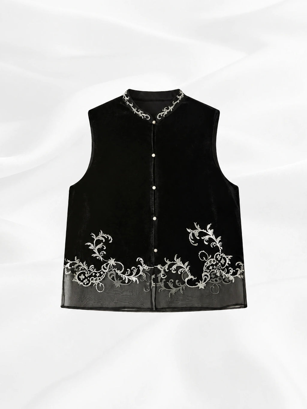 Front view of a black silk velvet vest with a Mandarin collar, pearl-style buttons and ivory embroidery.