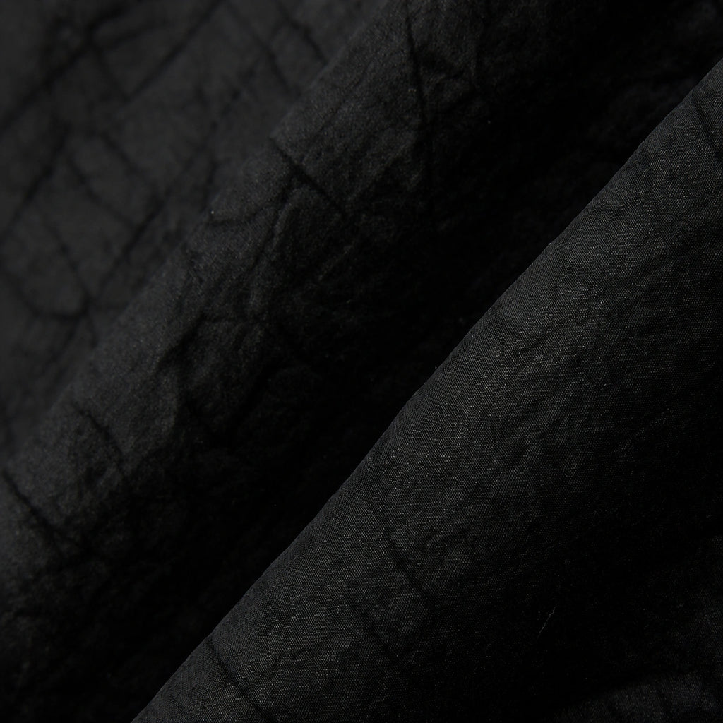 Macro view of the lightweight black Gambiered Silk fabric with a subtle tortoiseshell-inspired texture.