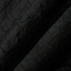 Macro view of the lightweight black Gambiered Silk fabric with a subtle tortoiseshell-inspired texture.