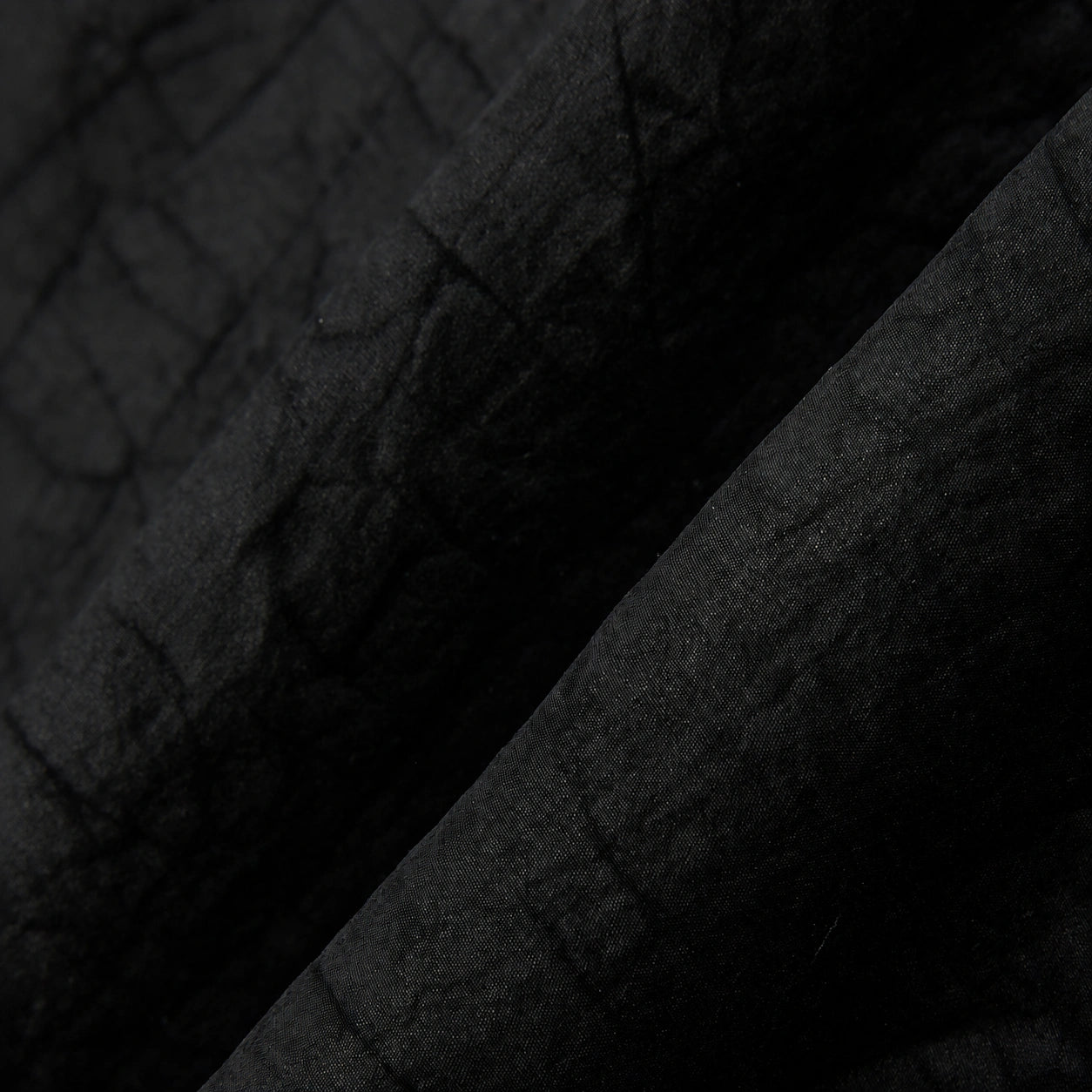 Macro view of the lightweight black Gambiered Silk fabric with a subtle tortoiseshell-inspired texture.