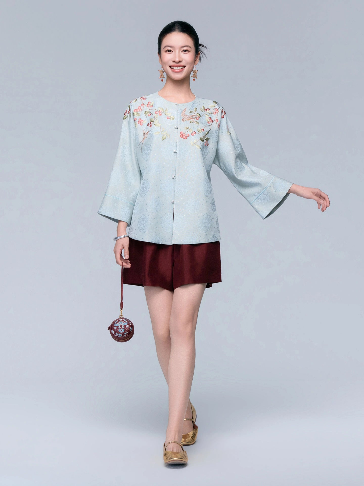 Front view of the powder blue silk-blend cardigan featuring botanical embroidery, wide sleeves and pearl-style buttons.