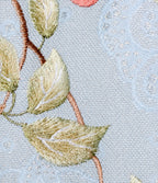 Close-up of the powder blue leno-weave fabric showing its open texture, subtle shimmer and embroidered leaves.