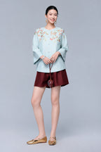 Full front view of the powder blue starlight leno cardigan styled with burgundy shorts and a round handbag.