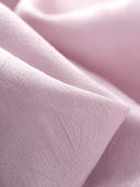 Close-up of blush-lilac textured rayon jacquard with subtle tonal floral motifs.