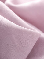 Close-up of blush-lilac textured rayon jacquard with subtle tonal floral motifs.