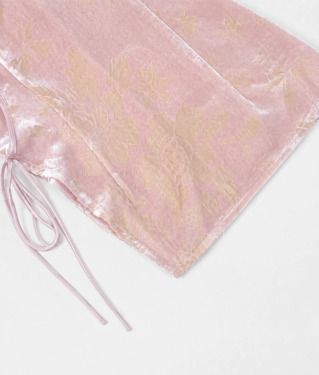 Close-up of blush-pink silk-blend cut-velvet fabric with champagne floral motifs and adjustable side ties