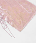 Close-up of blush-pink silk-blend cut-velvet fabric with champagne floral motifs and adjustable side ties