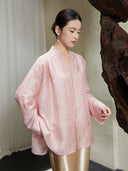 Angled view of the Blush Pink Lyocell Lace Trim V-Neck Blouse with covered buttons and soft jacquard texture.