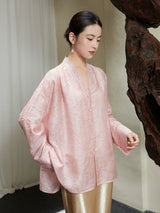 Angled view of the Blush Pink Lyocell Lace Trim V-Neck Blouse with covered buttons and soft jacquard texture.