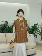 Full-length view of a model wearing a relaxed brown patterned silk top with white skirt