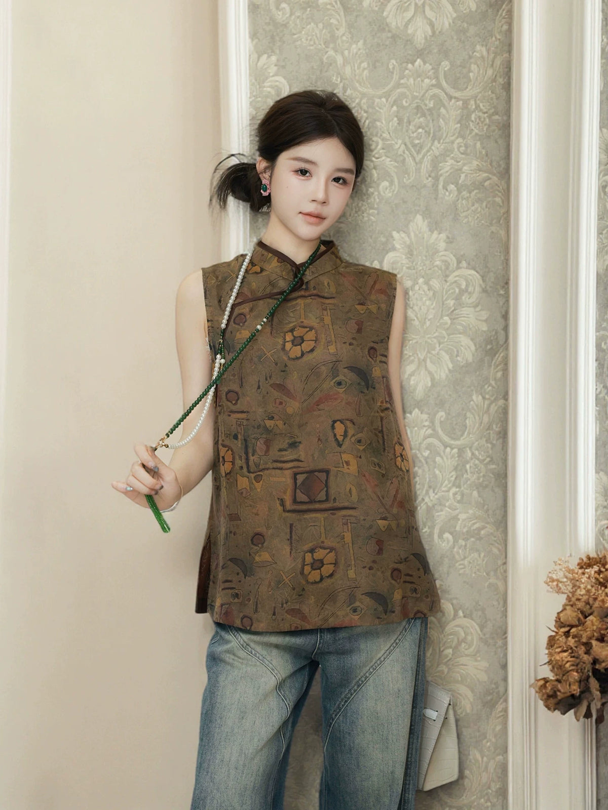 Model styling a relaxed brown patterned silk top with jeans and a white handbag