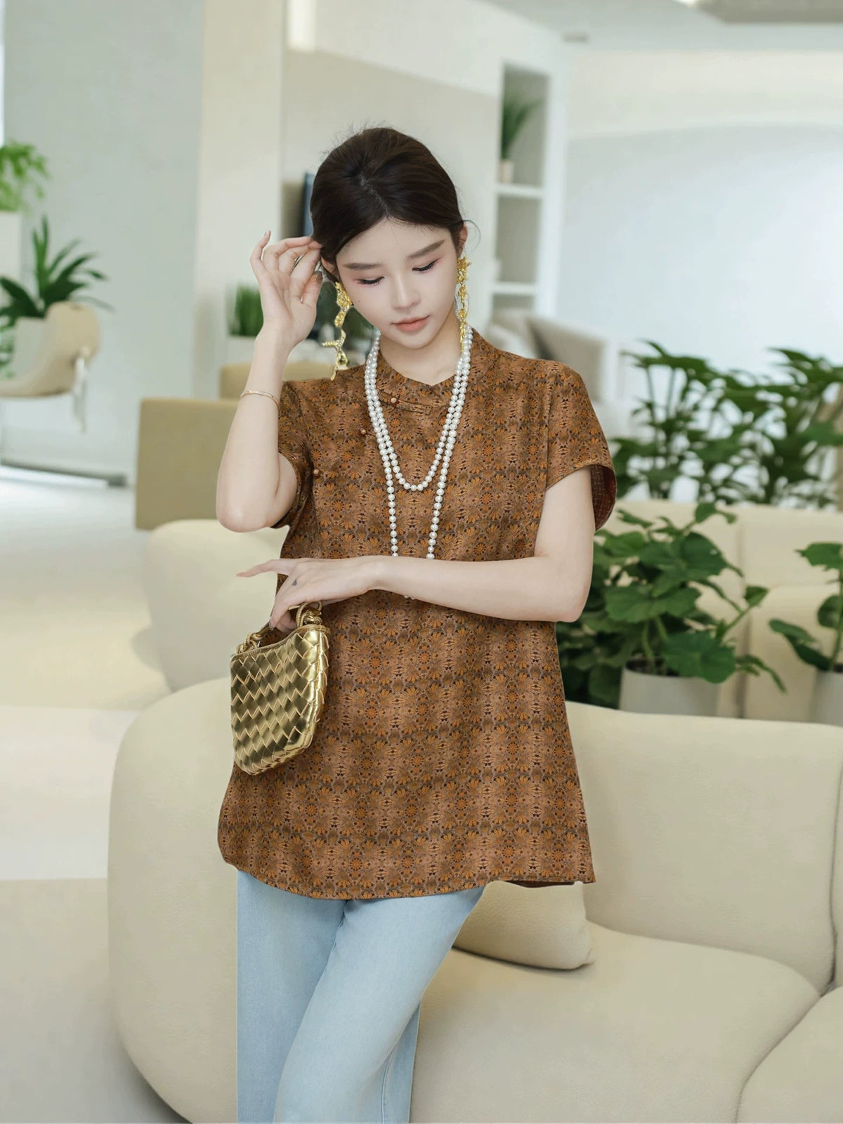 Side view of a model wearing a brown Chinese-inspired mulberry silk pullover top
