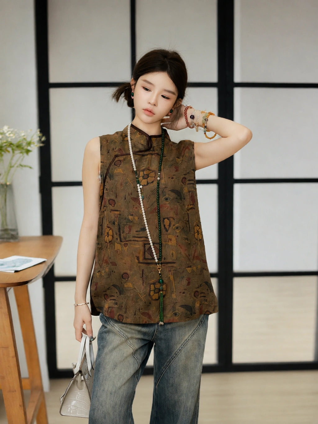 Model wearing a brown abstract-patterned silk top with casual denim trousers