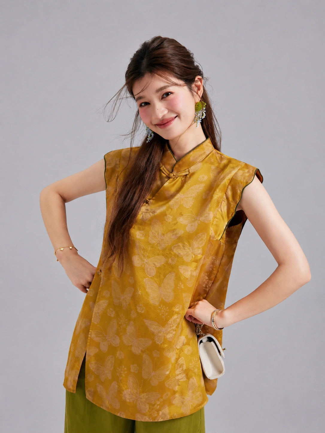 Model wearing a Gambiered Silk butterfly top with a Mandarin collar, flutter shoulders and asymmetric front closure