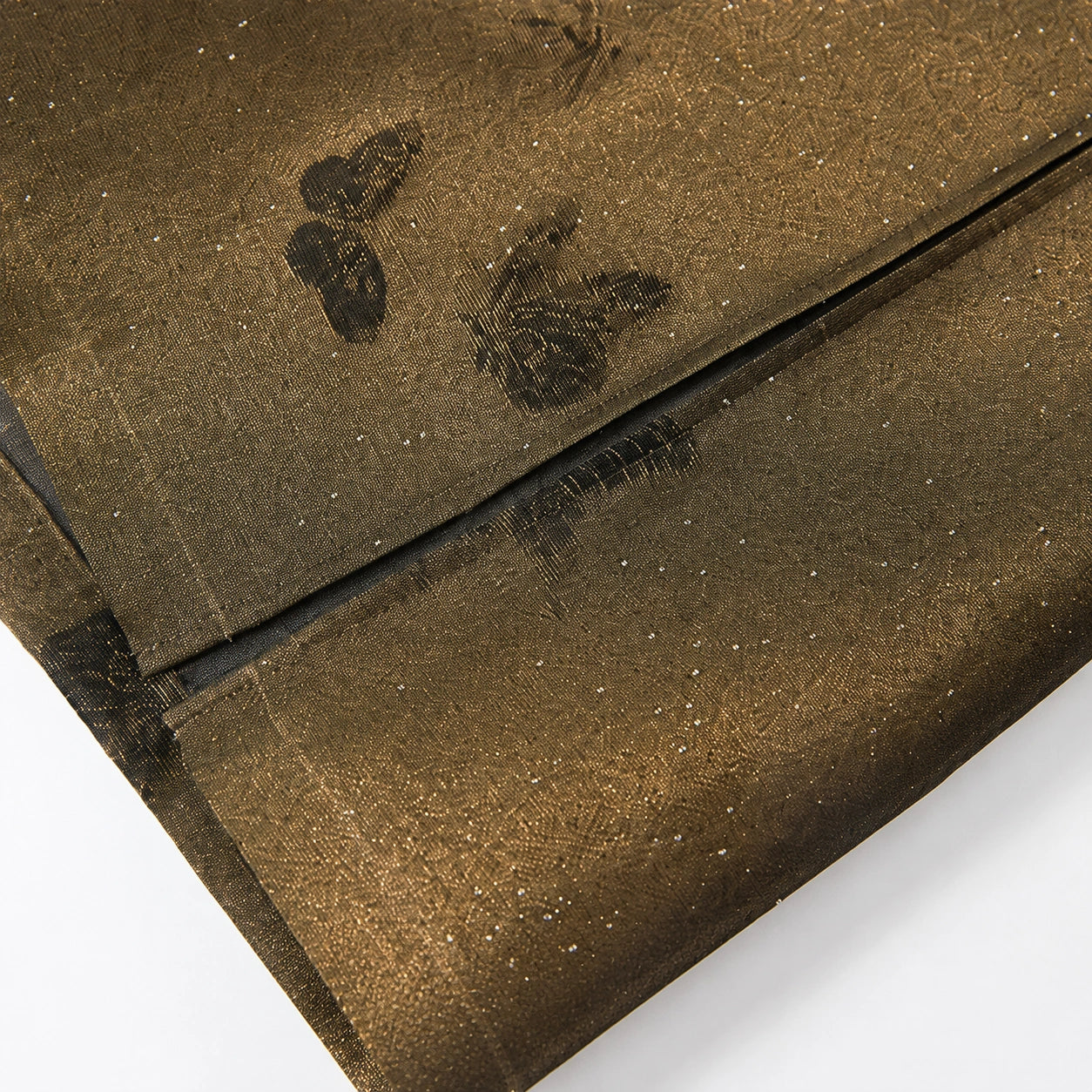 Close-up of the translucent silk-blend fabric with woven butterflies and fine sparkling accents