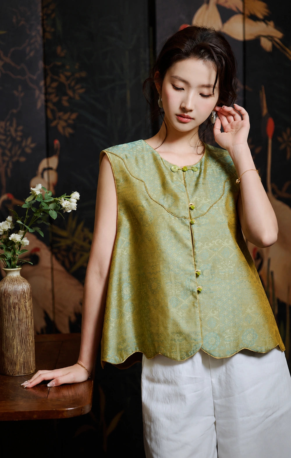 Upper-body view of the Chinese-inspired silk vest with a round neck and curved gold piping