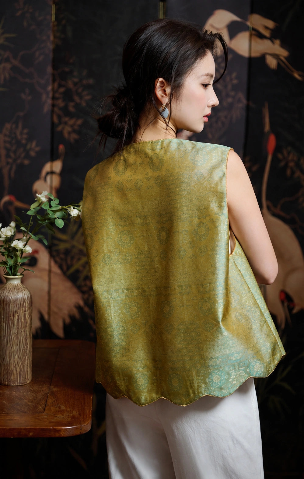 Back view of the relaxed celadon silk jacquard vest with a scalloped hem