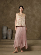 Front view of the champagne floral jacquard vest styled with a flowing pink skirt