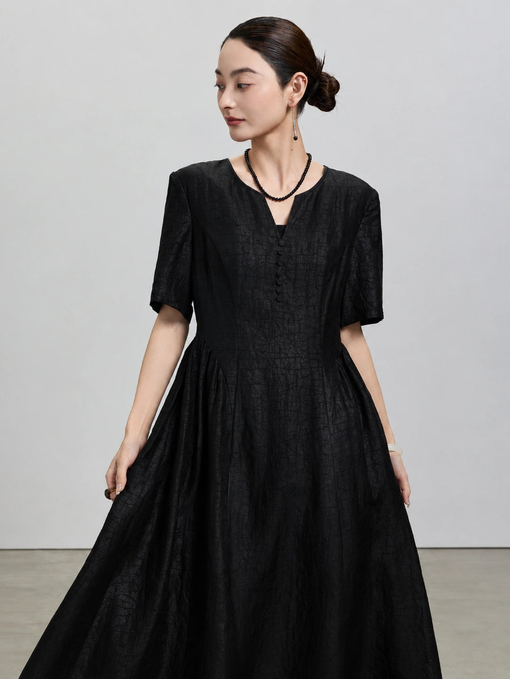 Front view of the black Hei Gui Xiangyunsha silk dress with a V-neck and sculpted waist