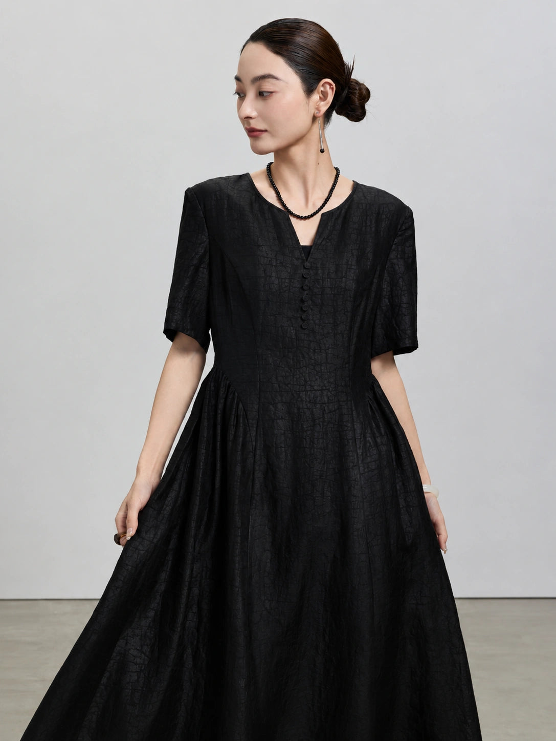 Front view of the black Hei Gui Xiangyunsha silk dress with a V-neck and sculpted waist