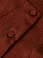 Close-up of matching silk-covered buttons and textured rust-brown mulberry silk fabric.