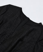 Close-up of the neckline construction, concealed zipper and tonal covered buttons