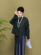 Model styling a relaxed dark green patterned silk jacket with a long skirt