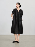 Full-length view of the dark purple H-line silk dress with scalloped sleeves and side pockets