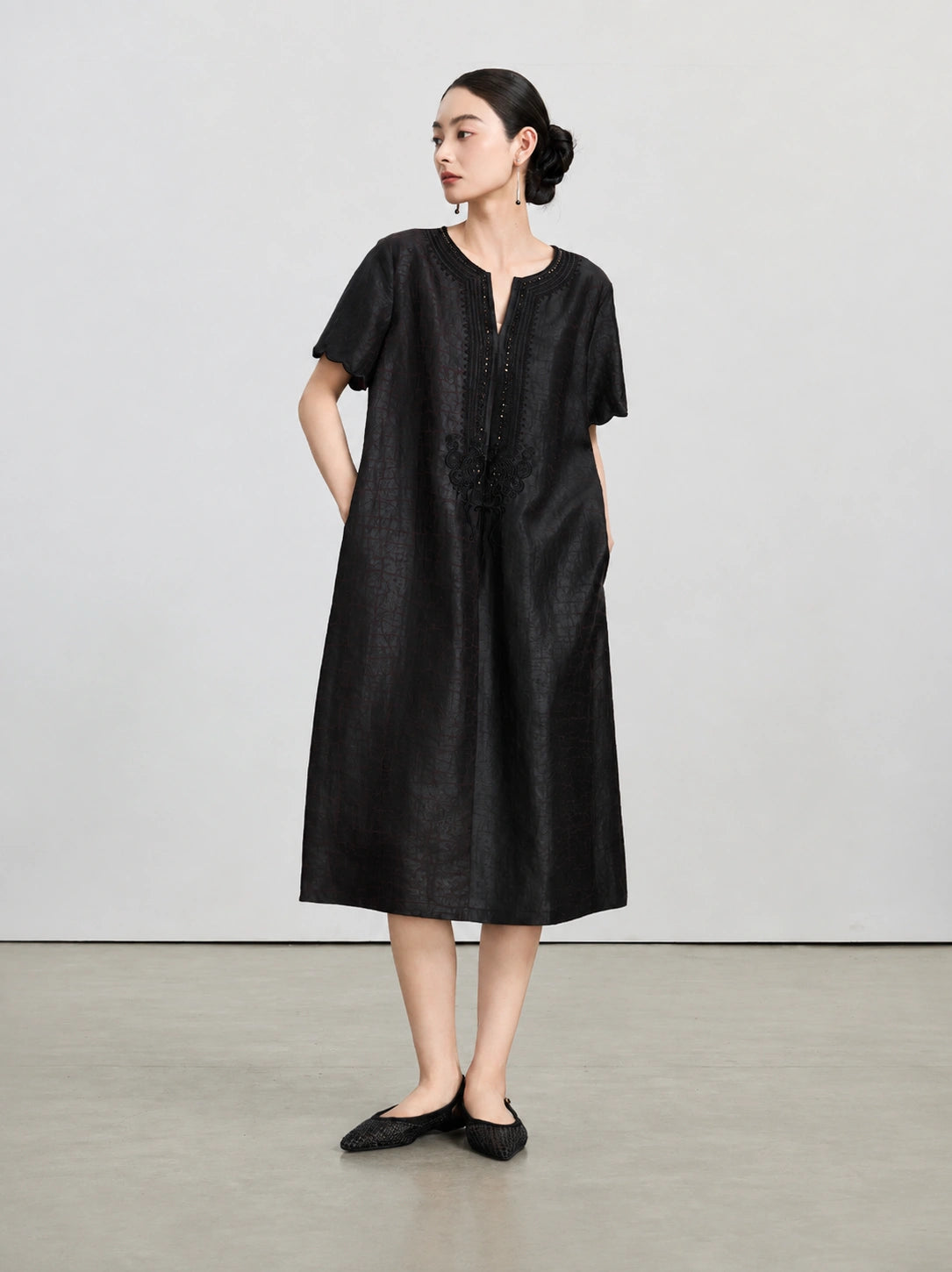 Full-length view of the dark purple H-line silk dress with scalloped sleeves and side pockets