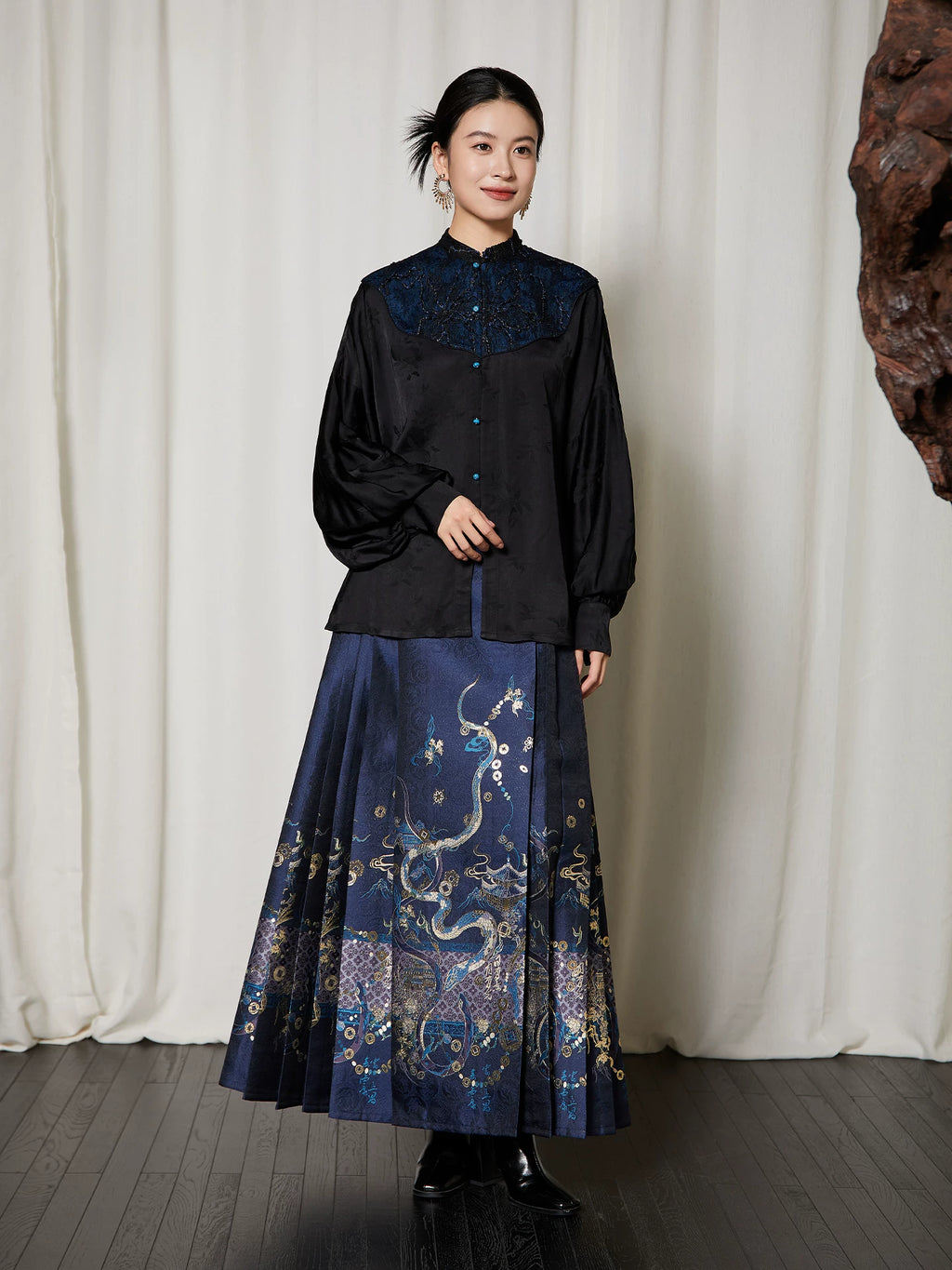 Lifestyle view of the Embroidered Mandarin Collar Viscose Blouse styled with a traditional-inspired pleated skirt.
