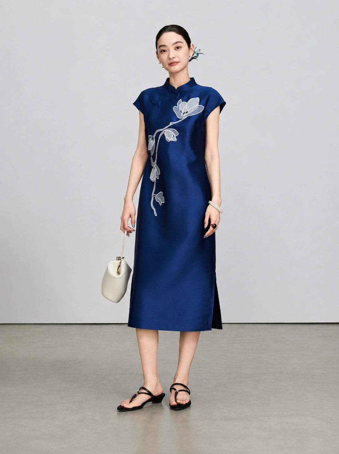 Front view of the navy midi qipao dress with white magnolia embroidery and stand collar