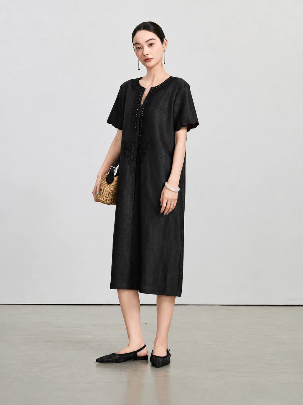 Front view of the dark aubergine silk dress with a beaded split V-neck and tonal embroidery