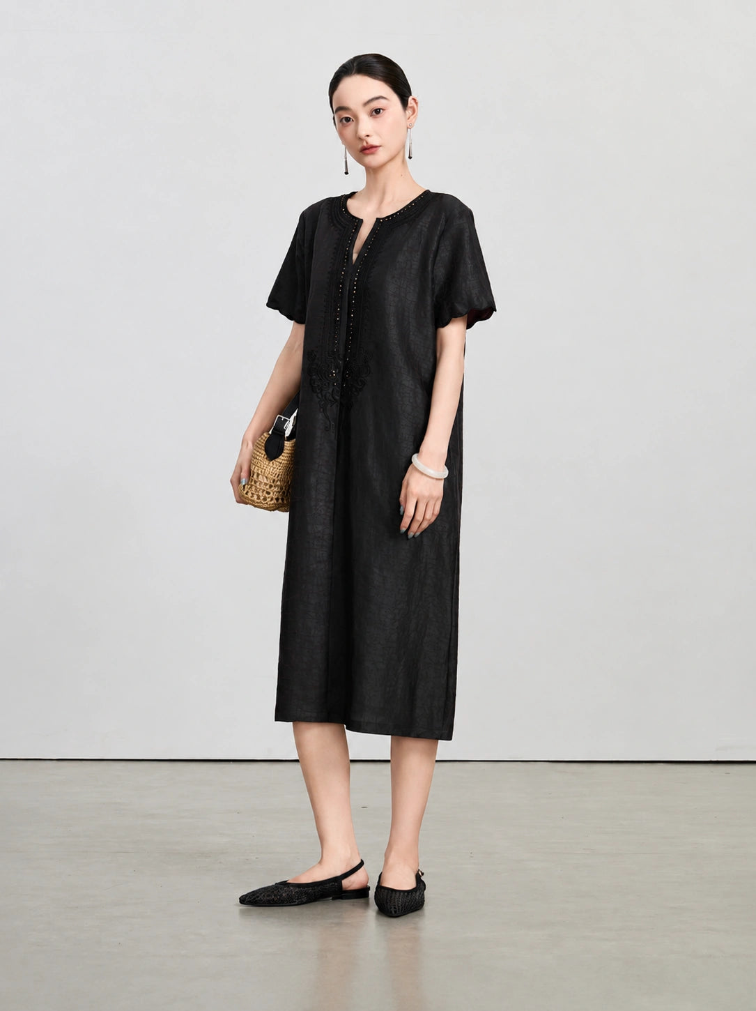 Front view of the dark aubergine silk dress with a beaded split V-neck and tonal embroidery