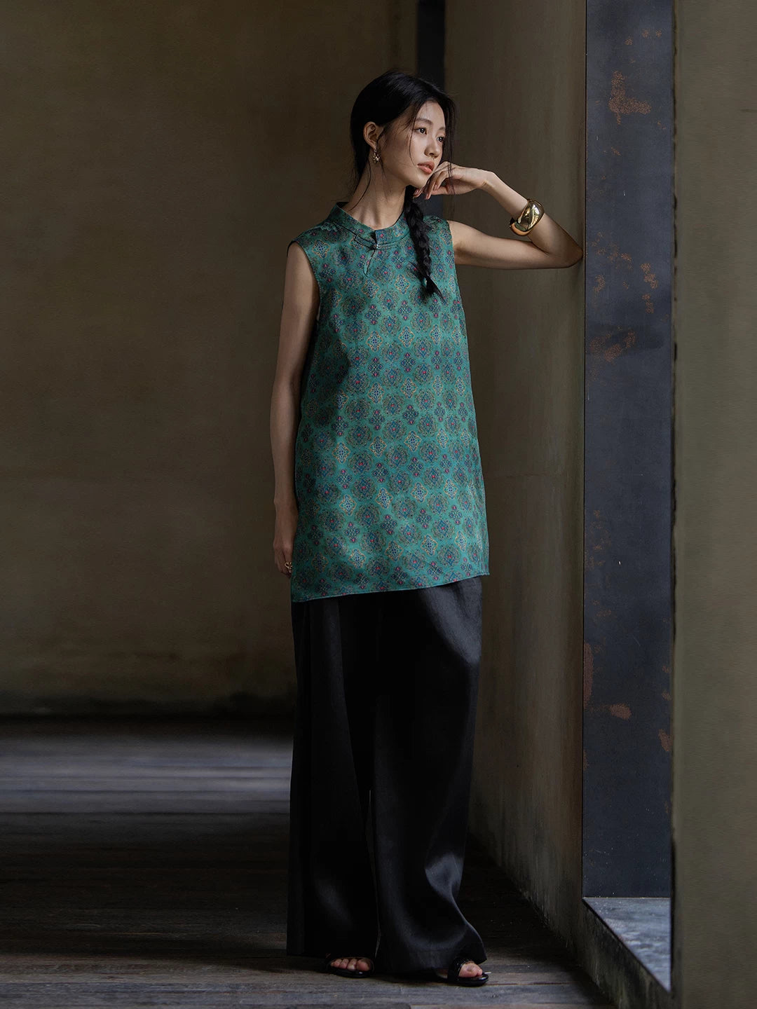 Side view of an emerald Gambiered Silk sleeveless tunic featuring a refined mandarin collar.