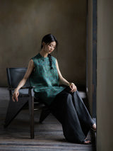 Model wearing an emerald Gambiered Silk sleeveless jacquard tunic with wide-leg trousers.