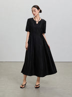 Full-length view showing the fitted bodice and flowing gathered skirt of the black silk dress