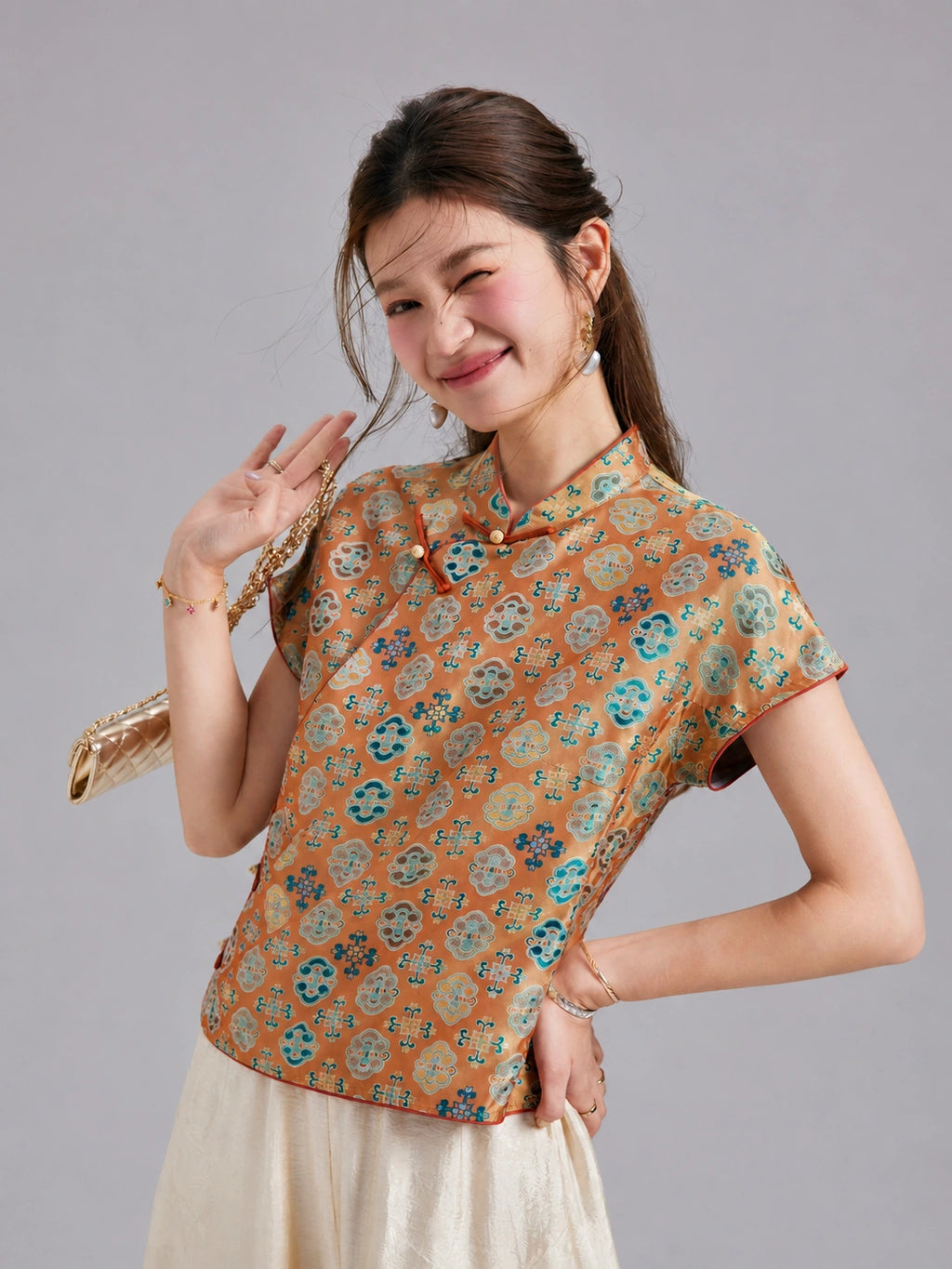 Model wearing a Gambiered Silk floral Shu brocade top with short sleeves and a contrast-trimmed Mandarin collar