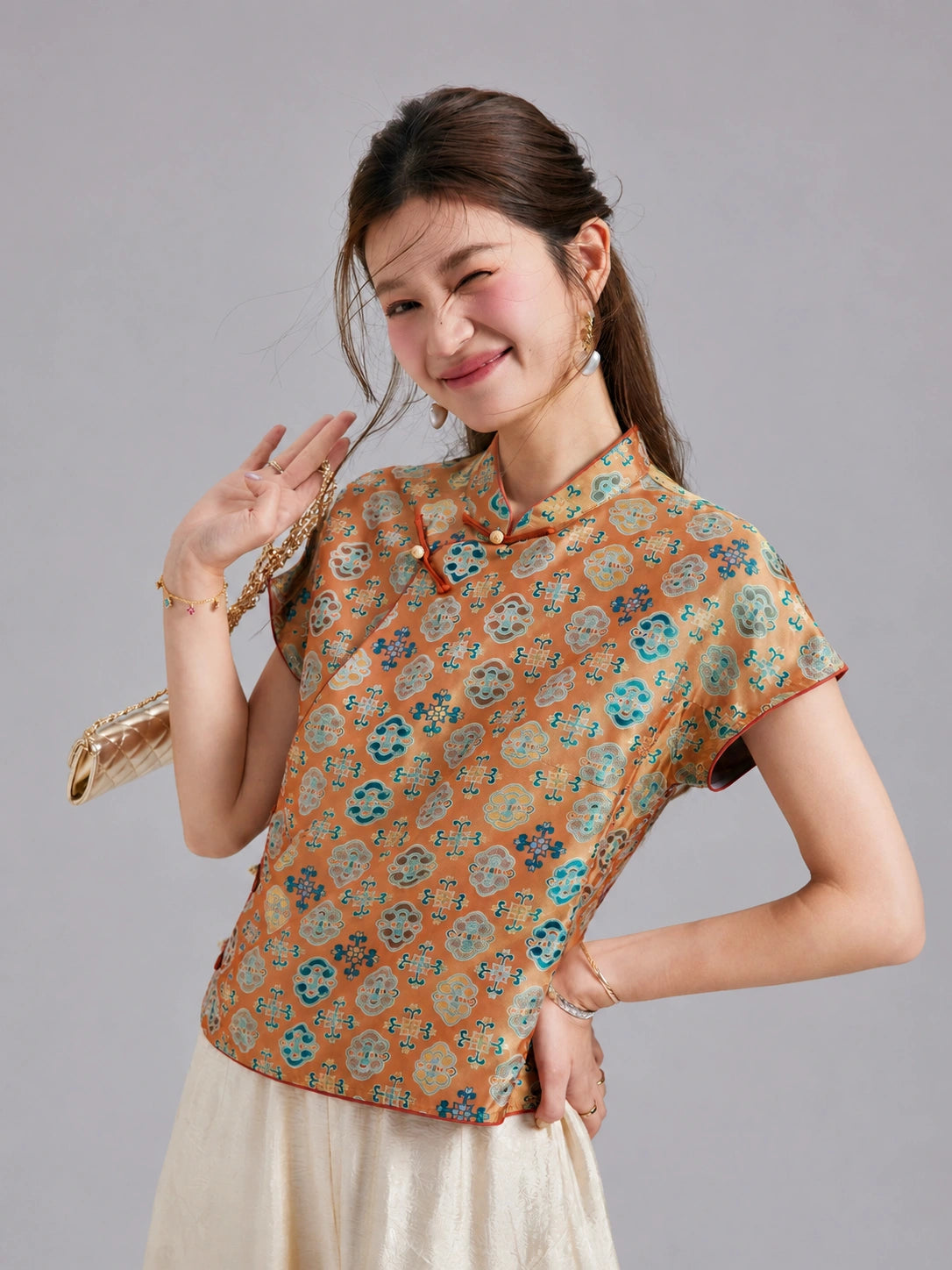 Model wearing a Gambiered Silk floral Shu brocade top with short sleeves and a contrast-trimmed Mandarin collar