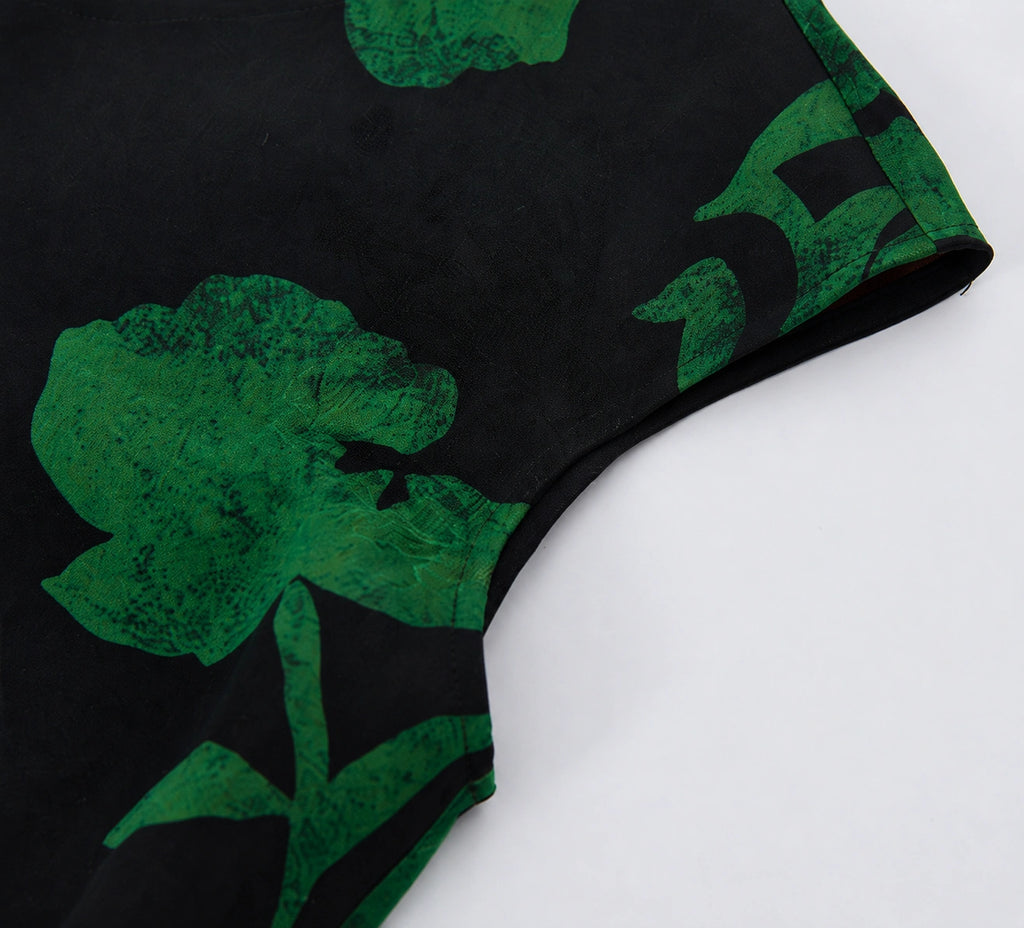 Close-up of the cap sleeve and emerald floral print on black Hua Luo silk fabric.