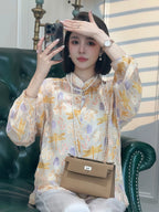 Model wearing a floral Chinese-inspired blouse with a mandarin collar and long sleeves