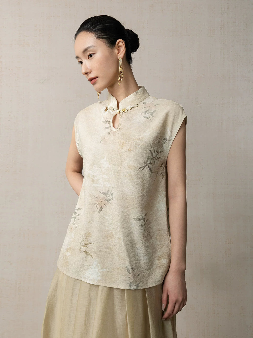 Woman wearing a warm sand floral mandarin collar sleeveless top with delicate botanical print by Gambiered Silk.