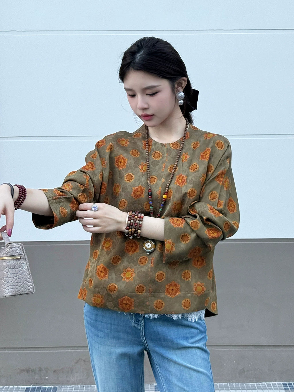 Side view of a model wearing an olive floral long-sleeve mulberry silk top