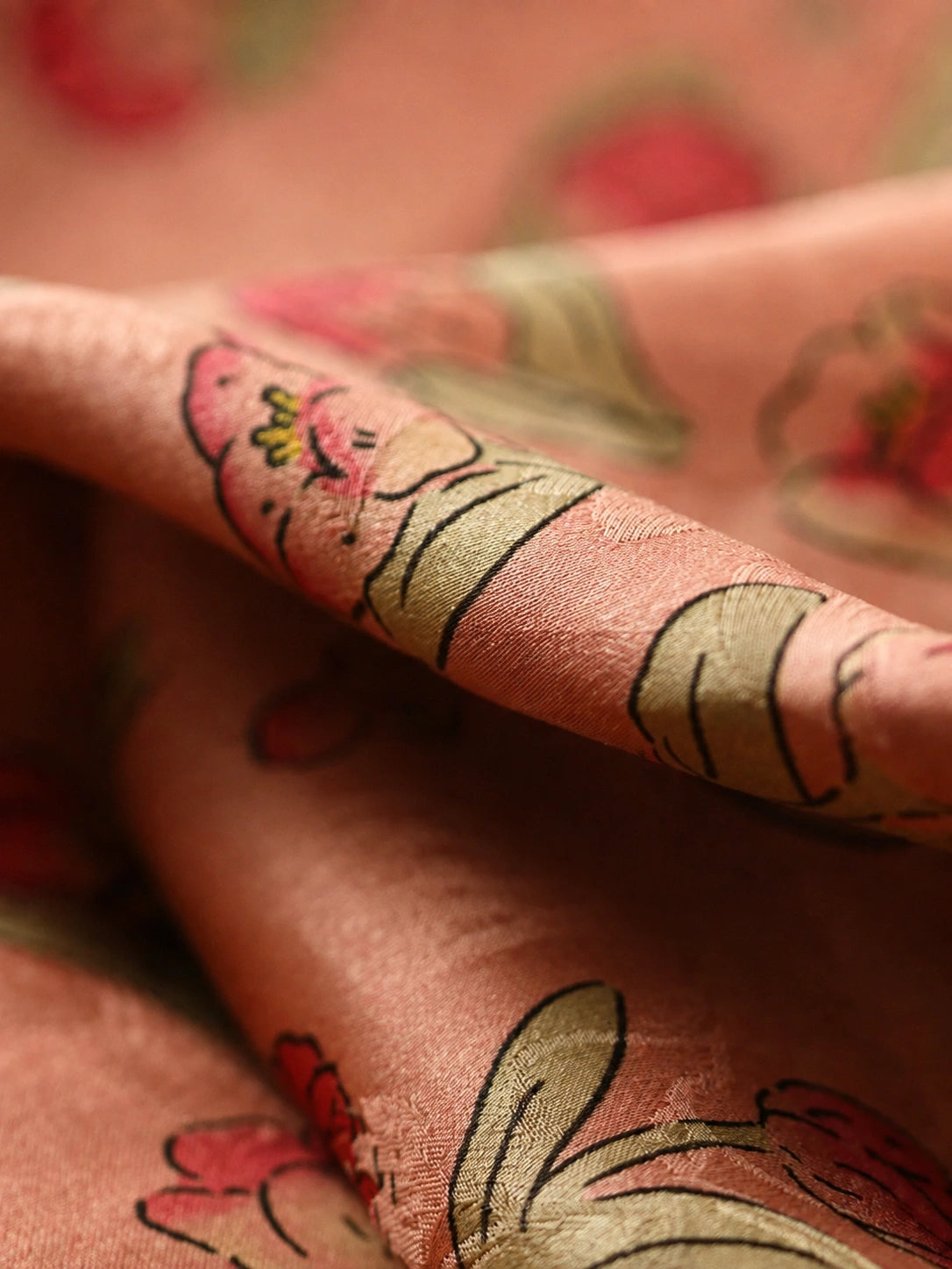 Close-up of coral pink mulberry silk jacquard fabric with woven floral, leaf and rabbit motifs