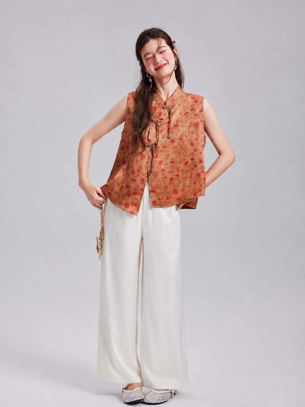 Model wearing a Gambiered Silk floral rabbit silk vest with white wide-leg trousers